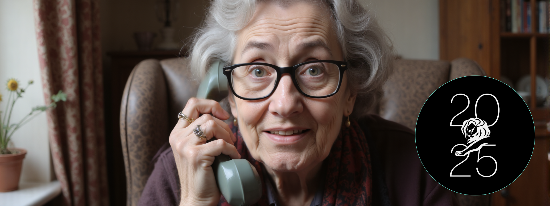 Elderly woman with gray hair and glasses speaking on a vintage telephone, seated in a cozy room with floral curtains and a potted daisy plant, with a Cannes Lions 2025 logo overlay.